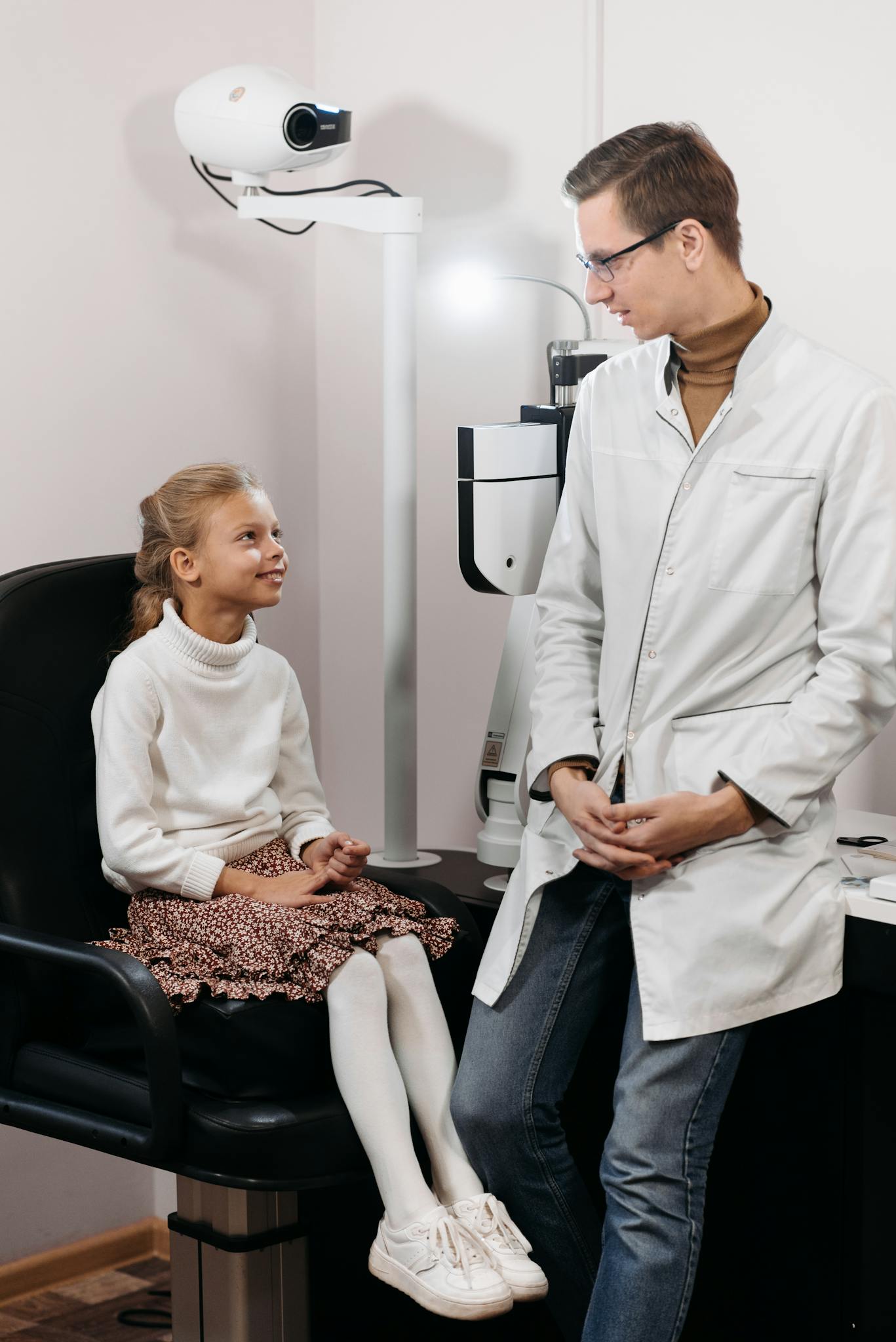 Young girl having an eye examination by a male ophthalmologist in a clinic.